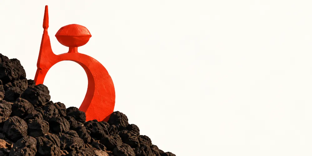 Escultura roja entre rocas volcánicas